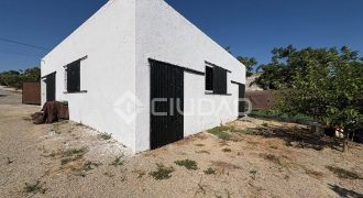 Terreno rústico con construcción e invernaderos